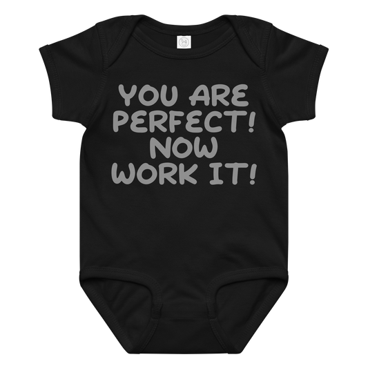 "You Are Perfect! Now Work It!" printed on a black baby jersey bodysuit laying on a flat surface amongst other clothes