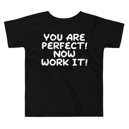 "You Are Perfect! Now Work It!" printed on a black toddler short sleeve tee laying on a flat surface