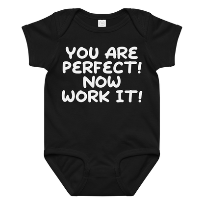 "You Are Perfect! Now Work It!" printed on a black baby jersey bodysuit laying on a flat surface amongst other clothes