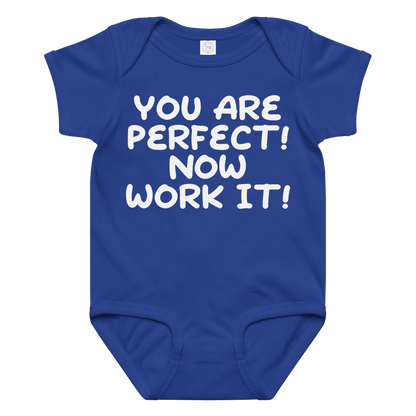 "You Are Perfect! Now Work It!" printed on a royal baby jersey bodysuit laying on a flat surface amongst other clothes