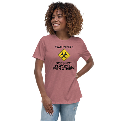 "!Warning! Does Not Play Well With Others" printed on a heather mauve women's relaxed t-shirt worn by a female