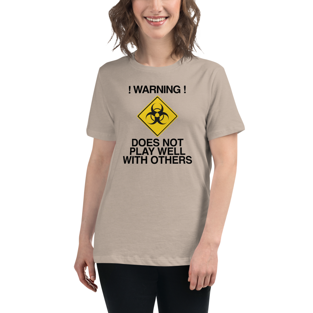 "!Warning! Does Not Play Well With Others" printed on a heather stone women's relaxed t-shirt worn by a female