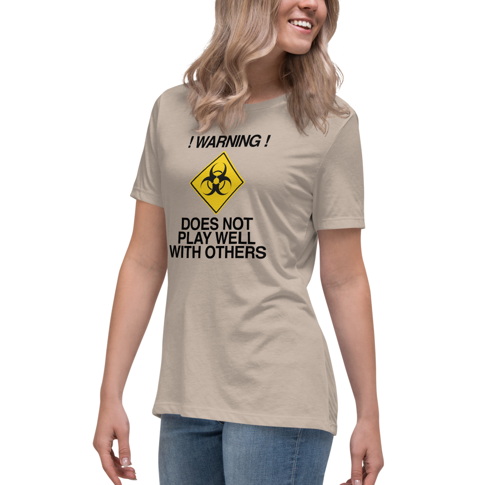 "!Warning! Does Not Play Well With Others" printed on a heather stone women's relaxed t-shirt worn by a female