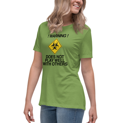 "!Warning! Does Not Play Well With Others" printed on a leaf women's relaxed t-shirt worn by a female
