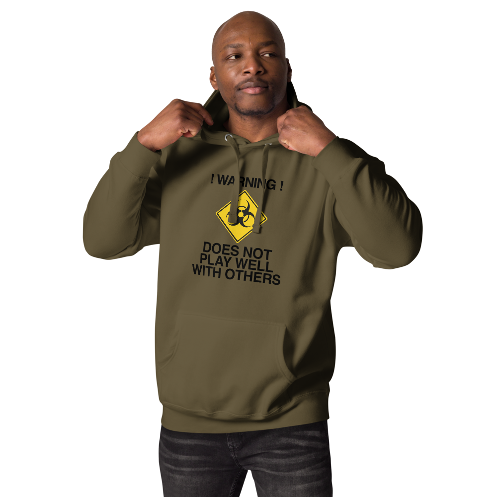 "!Warning! Does Not Play Well With Others" printed on a military green unisex hoodie worn by a male