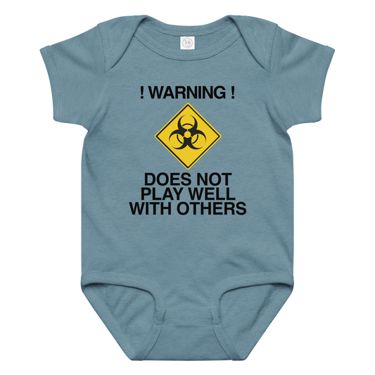 "!Warning! Does Not Play Well With Others" printed on a vintage indigo baby jersey bodysuit laying on a flat surface amongst other clothes