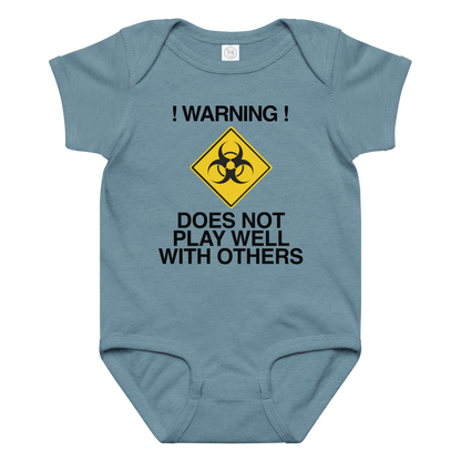 "!Warning! Does Not Play Well With Others" printed on a vintage indigo baby jersey bodysuit laying on a flat surface amongst other clothes