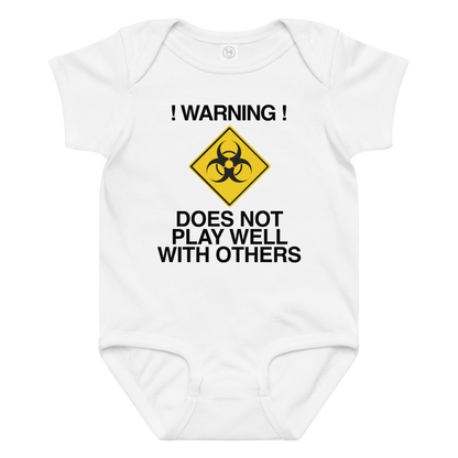 "!Warning! Does Not Play Well With Others" printed on a white baby jersey bodysuit laying on a flat surface amongst other clothes
