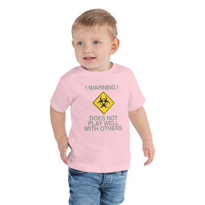 "!Warning! Does Not Play Well With Others" printed on a pink toddler short sleeve tee worn by a male