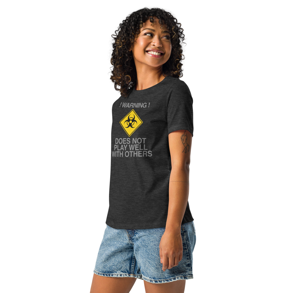 "!Warning! Does Not Play Well With Others" printed on a dark grey heather women's relaxed t-shirt worn by a female