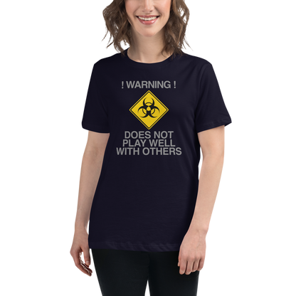 "!Warning! Does Not Play Well With Others" printed on a navy women's relaxed t-shirt worn by a female