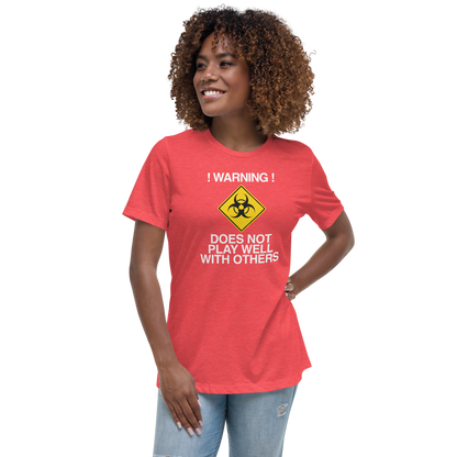 "!Warning! Does Not Play Well With Others" printed on a heather red women's relaxed t-shirt worn by a female