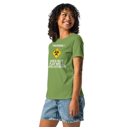 "!Warning! Does Not Play Well With Others" printed on a leaf women's relaxed t-shirt worn by a female