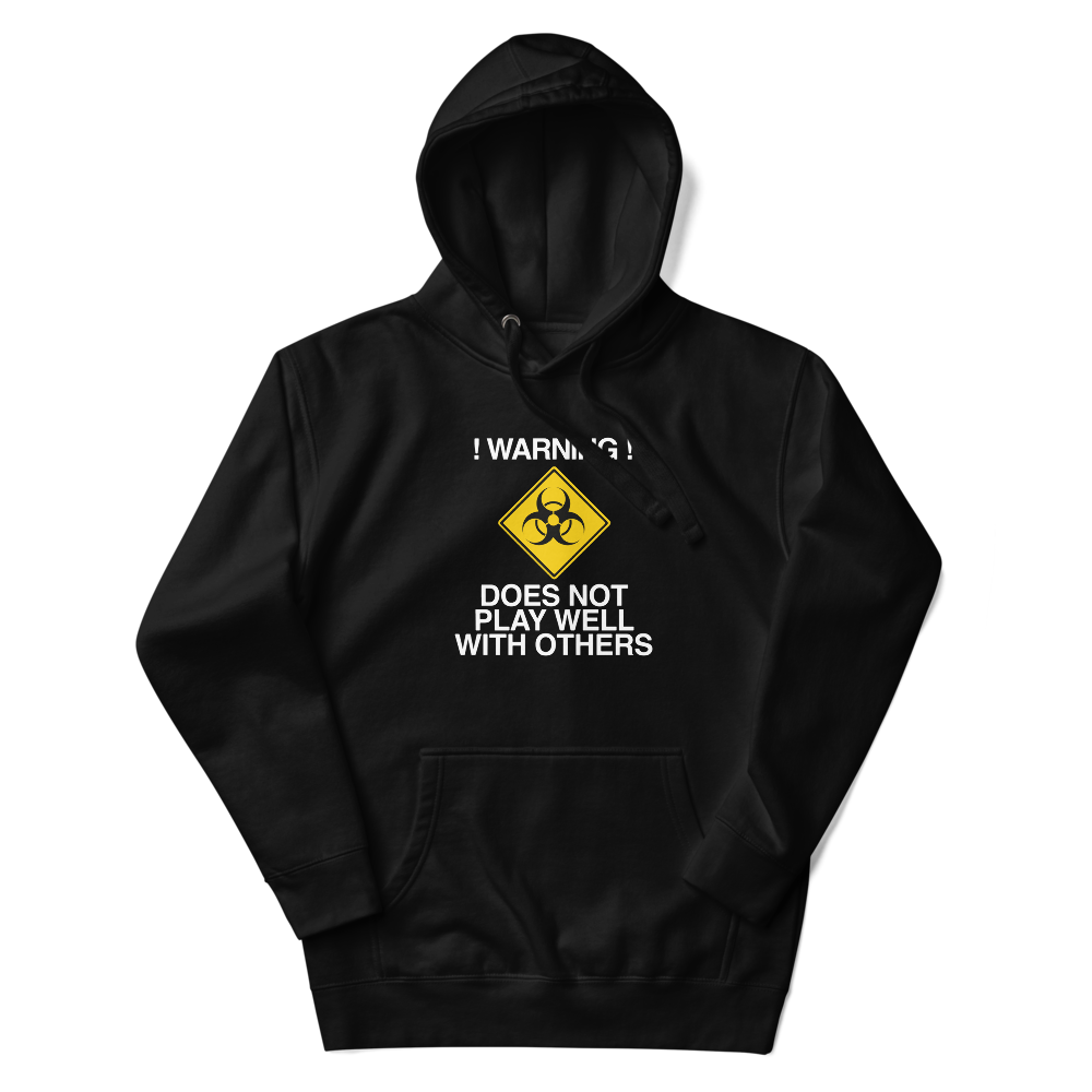 "!Warning! Does Not Play Well With Others" printed on a black unisex hoodie laying on a flat surface with the hood up