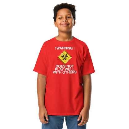 "!Warning! Does Not Play Well With Others" printed on a red youth classic tee worn by a male