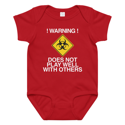 "!Warning! Does Not Play Well With Others" printed on a red baby jersey bodysuit laying on a flat surface amongst other clothes
