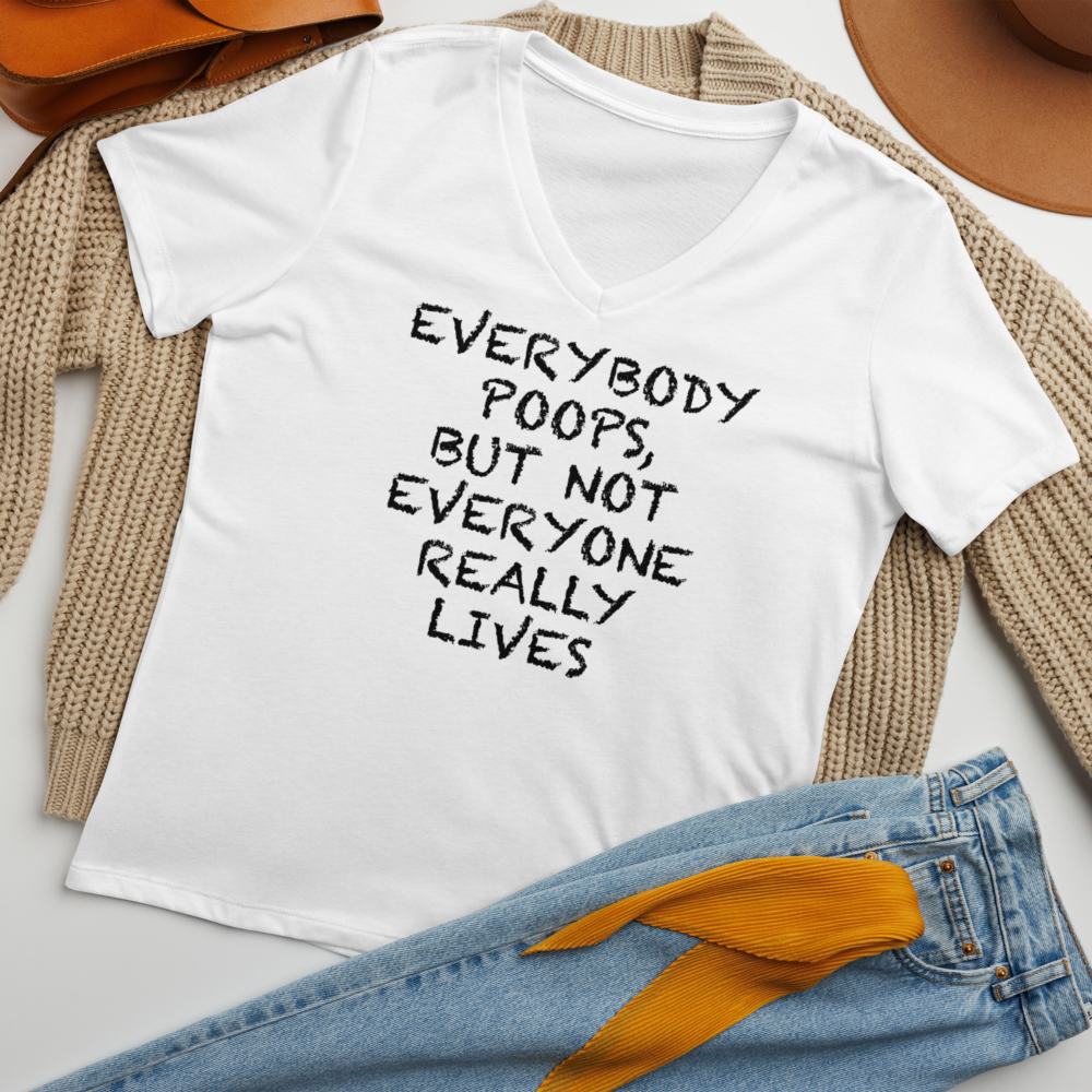 "Everybody poops, but not everyone really lives" printed on a solid white blend women's relaxed v-neck t-shirt laying on a flat surface amongst other clothes