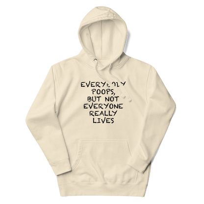 "Everybody poops, but not everyone really lives" printed on a bone unisex hoodie laying on a flat surface with the hood up