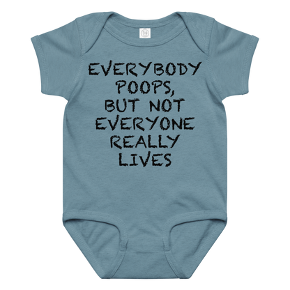"Everybody poops, but not everyone really lives" printed on a vintage indigo baby jersey bodysuit laying on a flat surface amongst other clothes