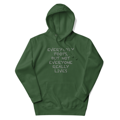 "Everybody poops, but not everyone really lives" printed on a forest green unisex hoodie laying on a flat surface with the hood up