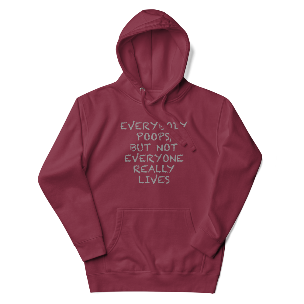 "Everybody poops, but not everyone really lives" printed on a maroon unisex hoodie laying on a flat surface with the hood up