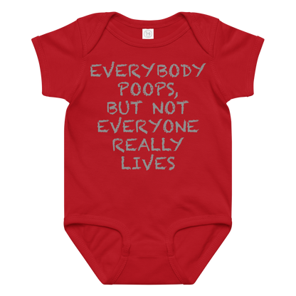 "Everybody poops, but not everyone really lives" printed on a red baby jersey bodysuit laying on a flat surface amongst other clothes