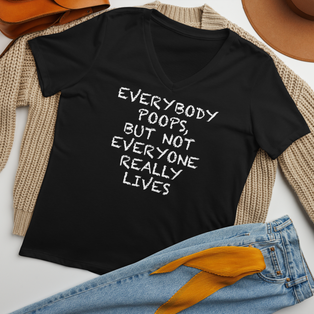 "Everybody poops, but not everyone really lives" printed on a solid black blend women's relaxed v-neck t-shirt laying on a flat surface amongst other clothes