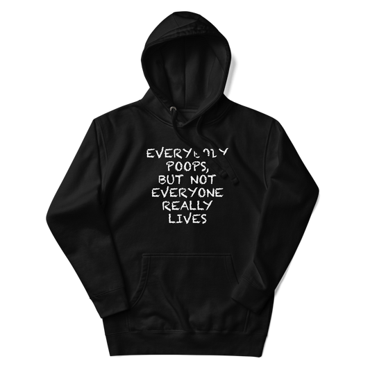 "Everybody poops, but not everyone really lives" printed on a black unisex hoodie laying on a flat surface with the hood up