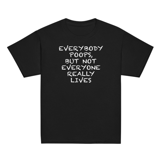 "Everybody poops, but not everyone really lives" printed on a black youth classic tee laying on a flat surface