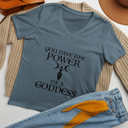 "You have the power of a goddess" printed on a heather slate women's relaxed v-neck t-shirt laying on a flat surface amongst other clothes