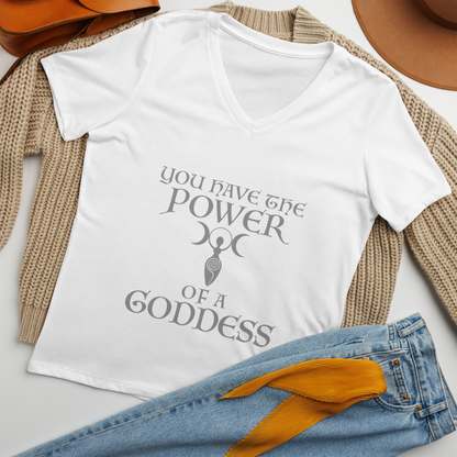 "You have the power of a goddess" printed on a solid white blend women's relaxed v-neck t-shirt laying on a flat surface amongst other clothes