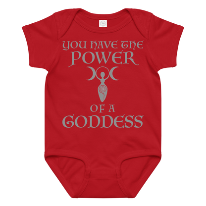 "You have the power of a goddess" printed on a red baby jersey bodysuit laying on a flat surface amongst other clothes