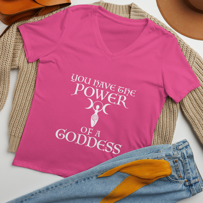 "You have the power of a goddess" printed on a berry women's relaxed v-neck t-shirt laying on a flat surface amongst other clothes