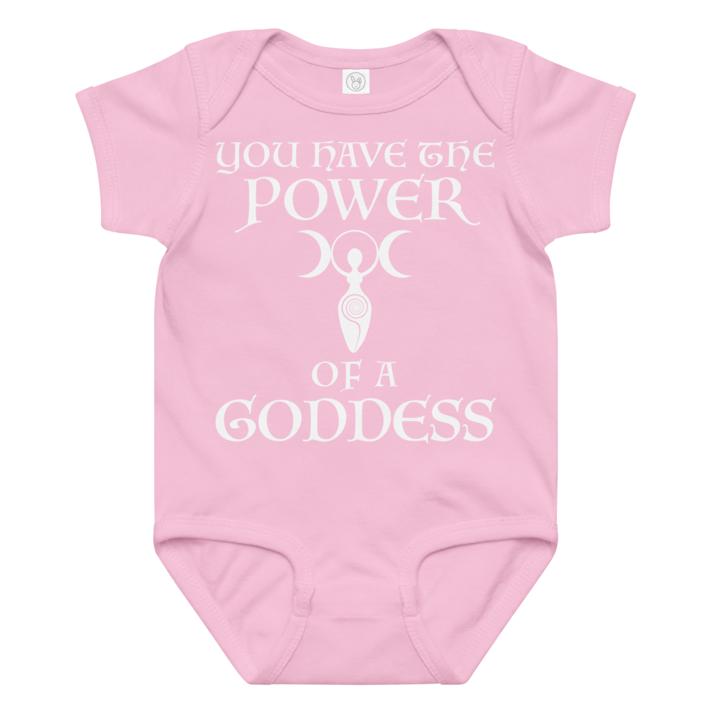 "You have the power of a goddess" printed on a pink baby jersey bodysuit laying on a flat surface amongst other clothes