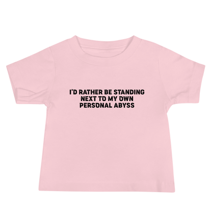 "I'd rather be standing next to my own personal abyss" printed on a pink baby jersey short sleeve tee laying on a flat surface