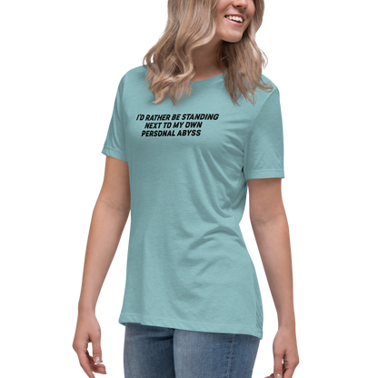 "I'd rather be standing next to my own personal abyss" printed on a heather blue lagoon women's relaxed t-shirt worn by a female