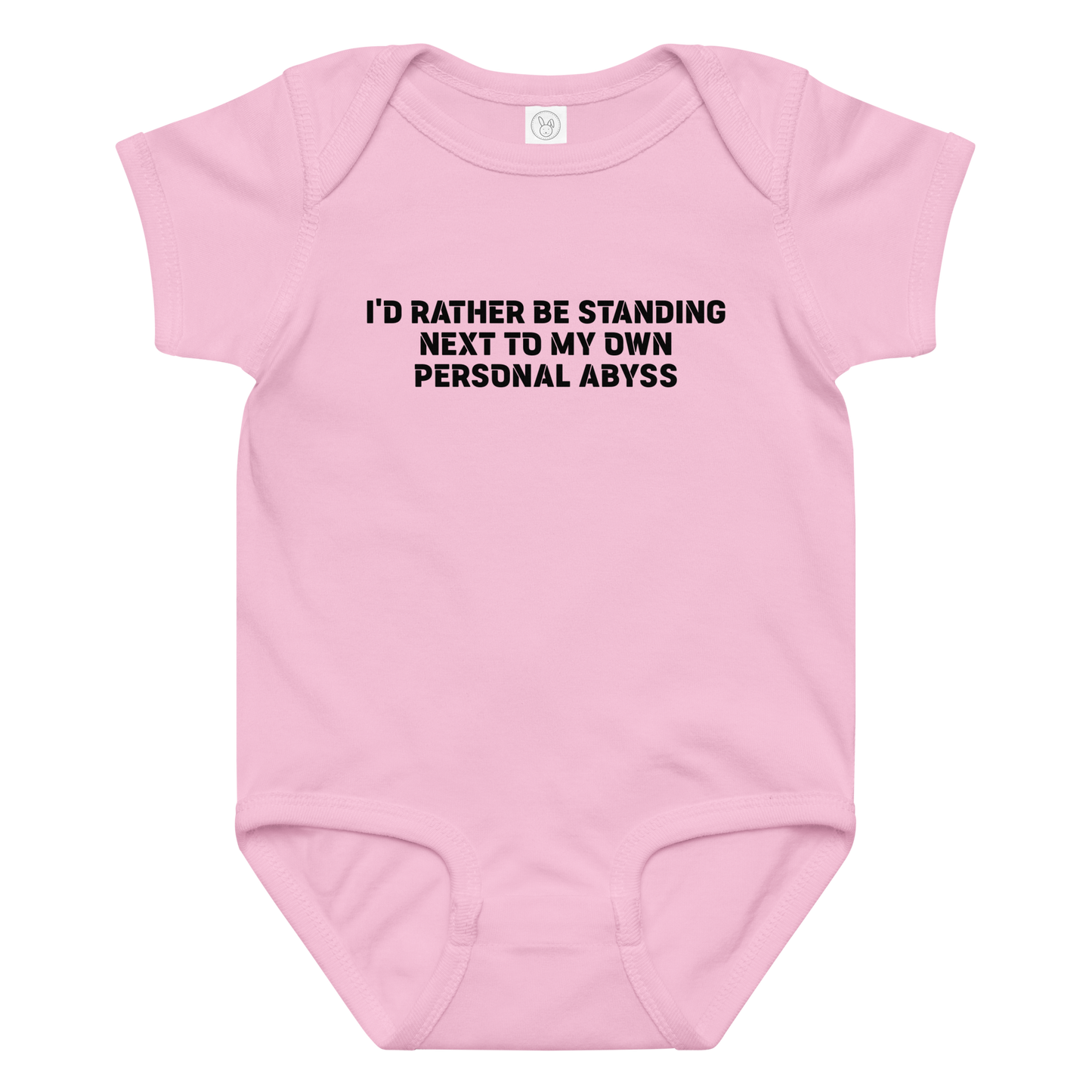 "I'd rather be standing next to my own personal abyss" printed on a pink baby jersey bodysuit laying on a flat surface amongst other clothes