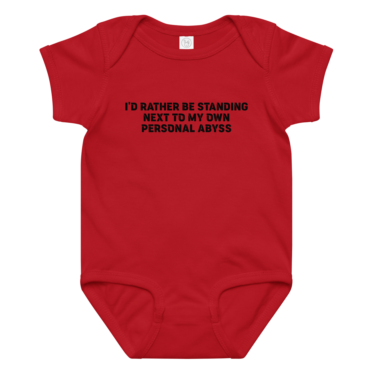 "I'd rather be standing next to my own personal abyss" printed on a red baby jersey bodysuit laying on a flat surface amongst other clothes