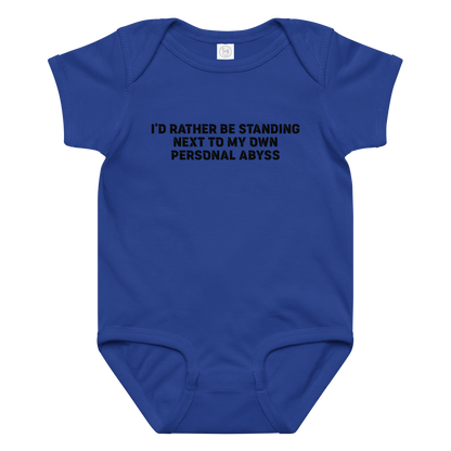 "I'd rather be standing next to my own personal abyss" printed on a royal baby jersey bodysuit laying on a flat surface amongst other clothes