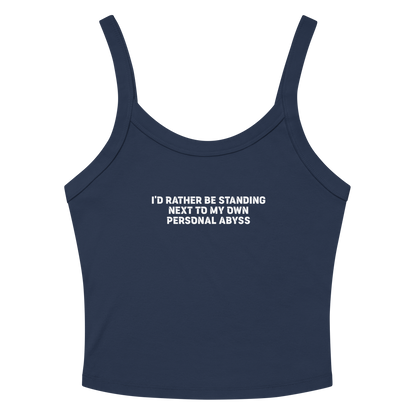 "I'd rather be standing next to my own personal abyss" printed on a solid navy blend women's micro-rib tanktop laying on a flat surface amongst sunglasses and shorts