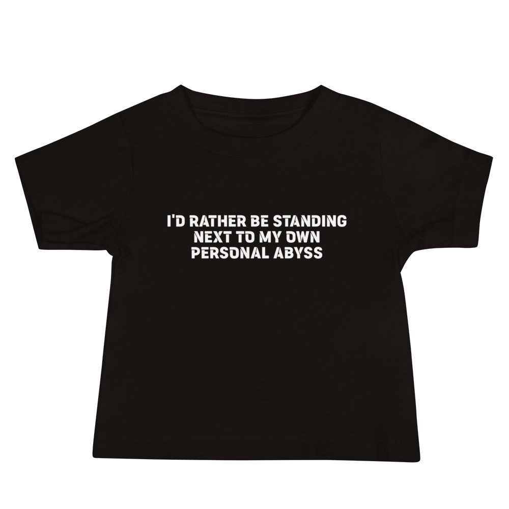 "I'd rather be standing next to my own personal abyss" printed on a black baby jersey short sleeve tee laying on a flat surface