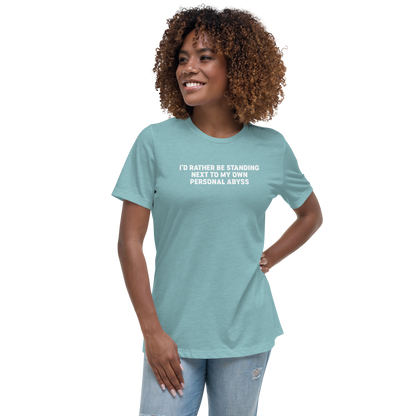"I'd rather be standing next to my own personal abyss" printed on a heather blue lagoon women's relaxed t-shirt worn by a female