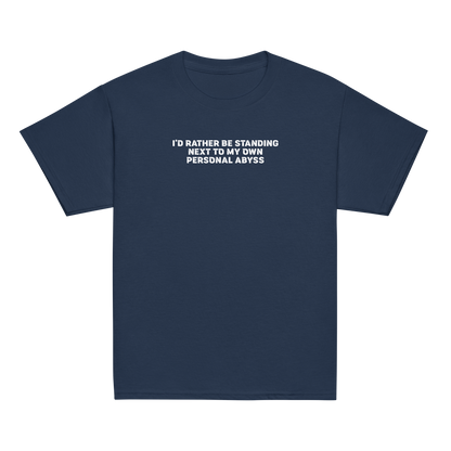 "I'd rather be standing next to my own personal abyss" printed on a navy youth classic tee laying on a flat surface