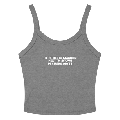"I'd rather be standing next to my own personal abyss" printed on a athletic heather women's micro-rib tanktop laying on a flat surface amongst sunglasses and shorts