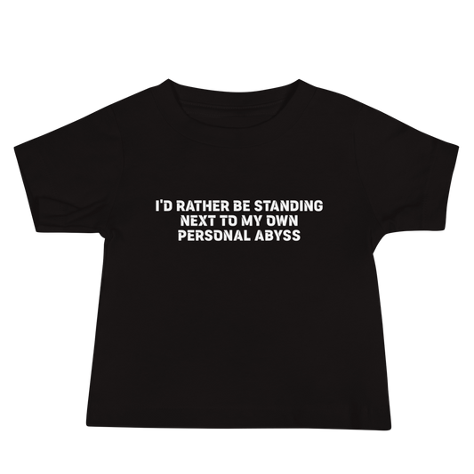 "I'd rather be standing next to my own personal abyss" printed on a black baby jersey short sleeve tee laying on a flat surface