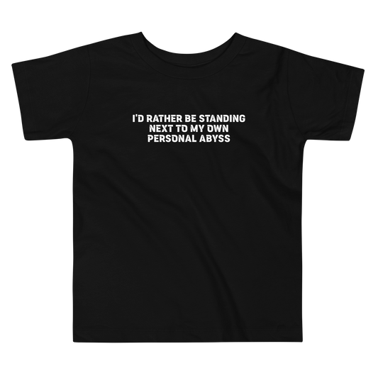 "I'd rather be standing next to my own personal abyss" printed on a black toddler short sleeve tee laying on a flat surface