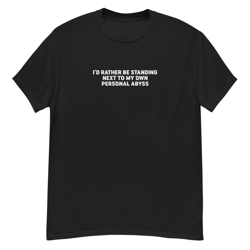 "I'd rather be standing next to my own personal abyss" printed on a black unisex classic tee laying on a flat surface