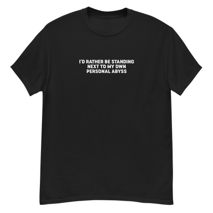 "I'd rather be standing next to my own personal abyss" printed on a black unisex classic tee laying on a flat surface
