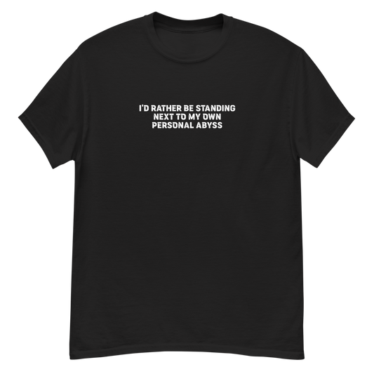 "I'd rather be standing next to my own personal abyss" printed on a black unisex classic tee laying on a flat surface