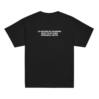 "I'd rather be standing next to my own personal abyss" printed on a black youth classic tee laying on a flat surface